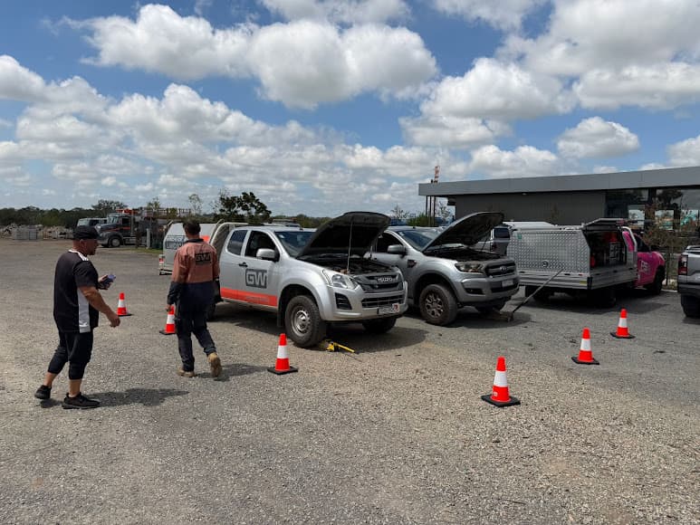 Two work utes with their bonnets open beside a PSA service ute at a work site