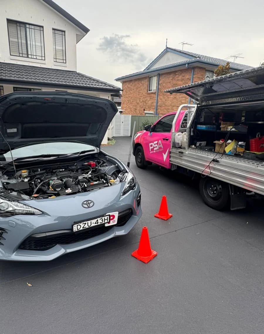 A Toyota with its bonnet open beside a PSA service ute